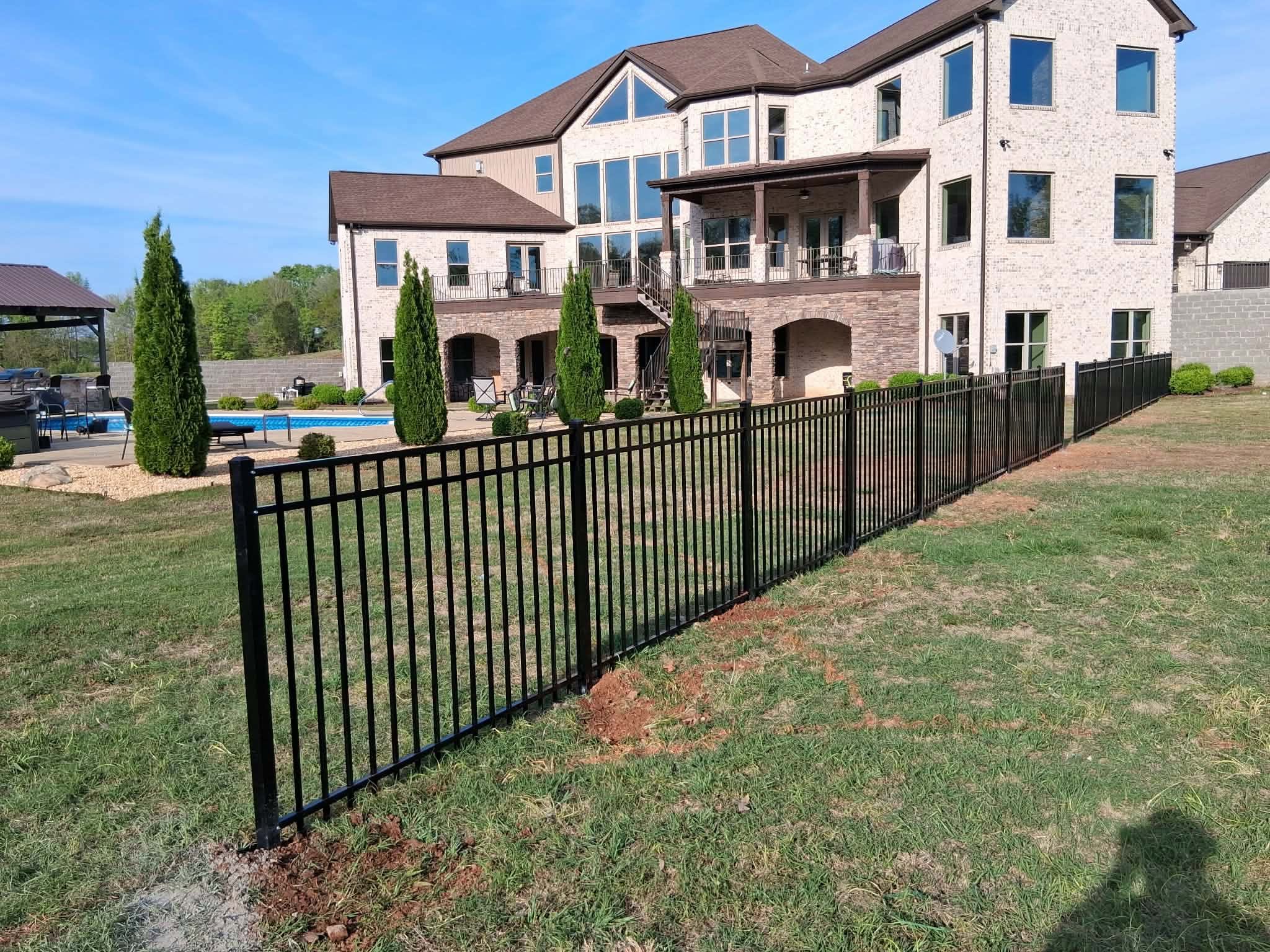 Request a fence quote — Vaughn Fence Muscle Shoals, AL Black ornamental metal fence around a pool and patio in Muscle Shoals, AL