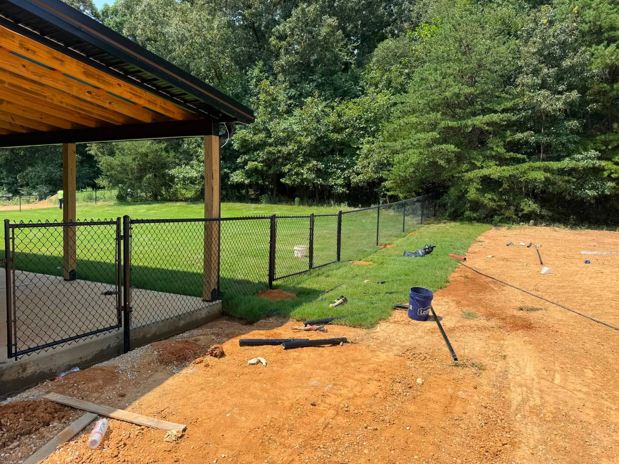 Black chain-link fence and gate beside a covered patio in Muscle Shoals, AL Black chain-link fence and gate beside a covered patio in Muscle Shoals, AL