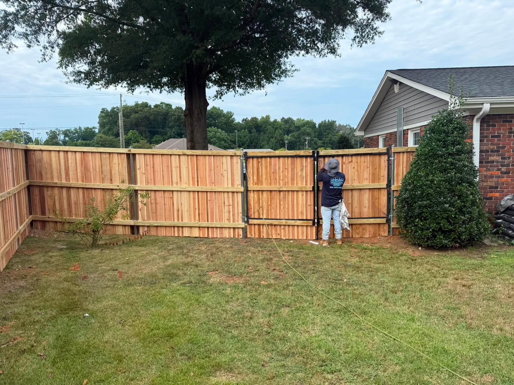 Vaughn Fence crew finishing a wooden privacy fence double gate in Colbert County, AL Vaughn Fence crew finishing a wooden privacy fence double gate in Colbert County, AL