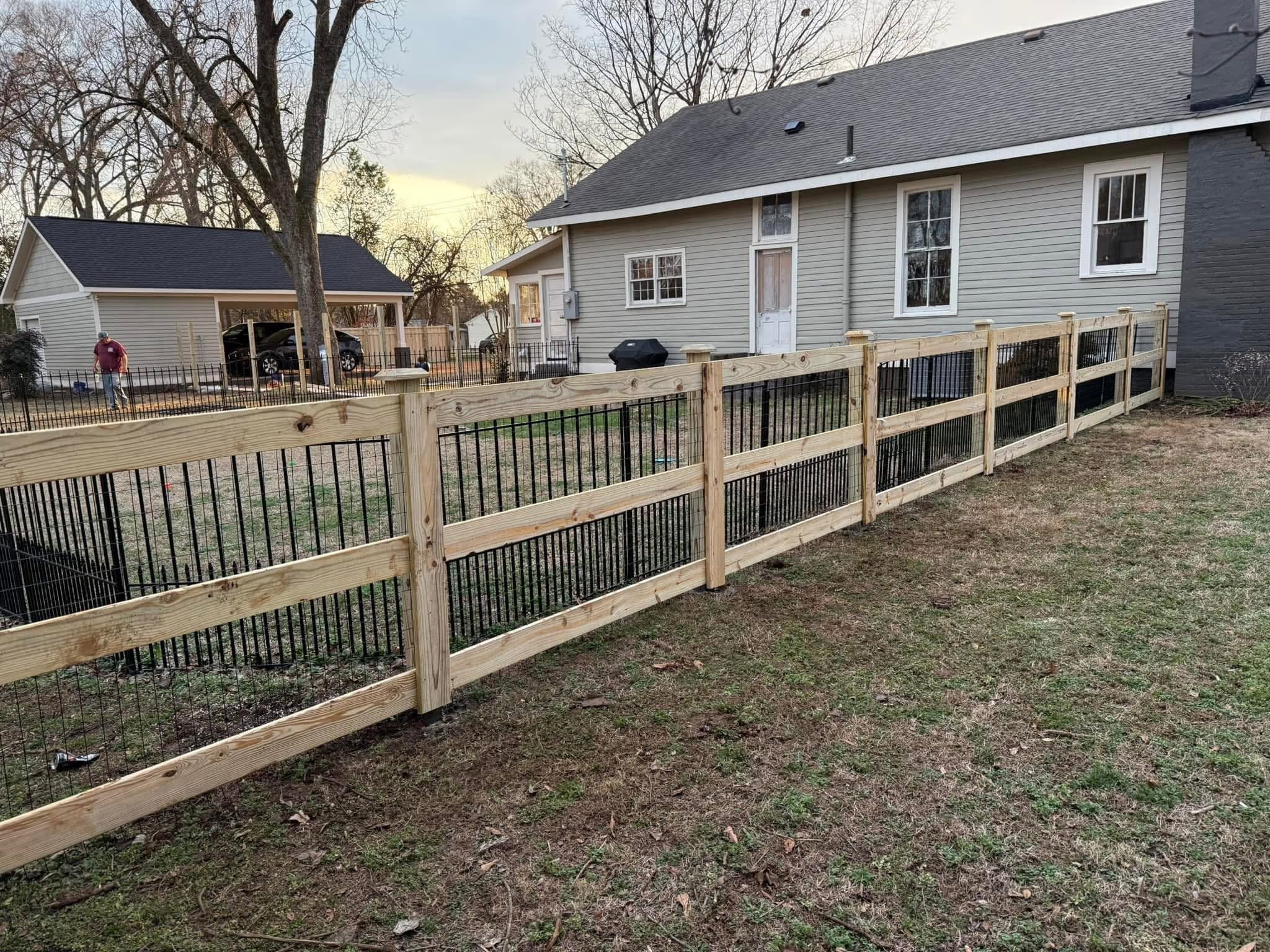 Hybrid wood-and-black-metal picket fence along a residential yard in Northern Alabama Hybrid wood-and-black-metal picket fence along a residential yard in Northern Alabama
