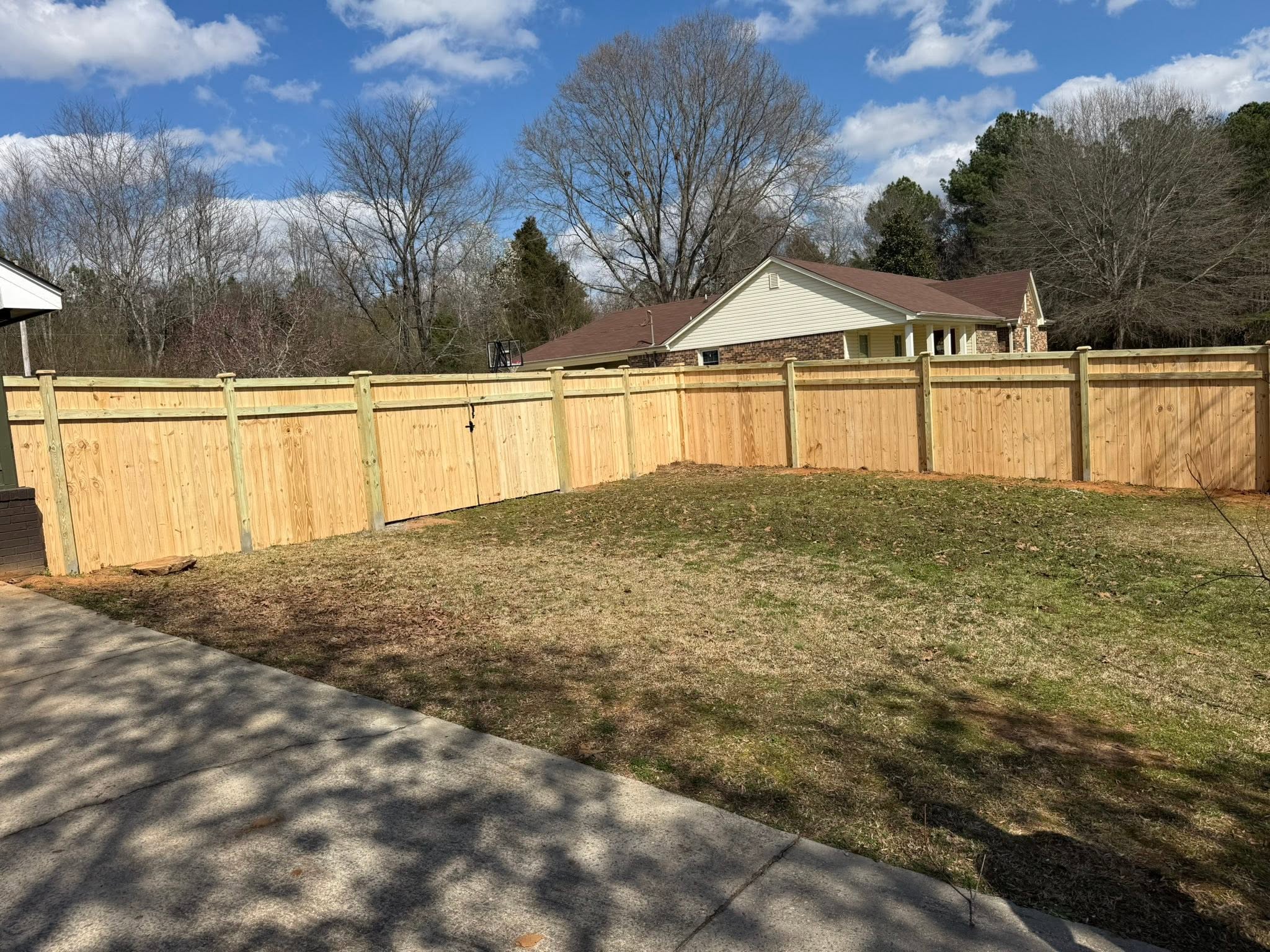 Completed wood privacy fence with double gate for a ranch home in Colbert County, AL Completed wood privacy fence with double gate for a ranch home in Colbert County, AL