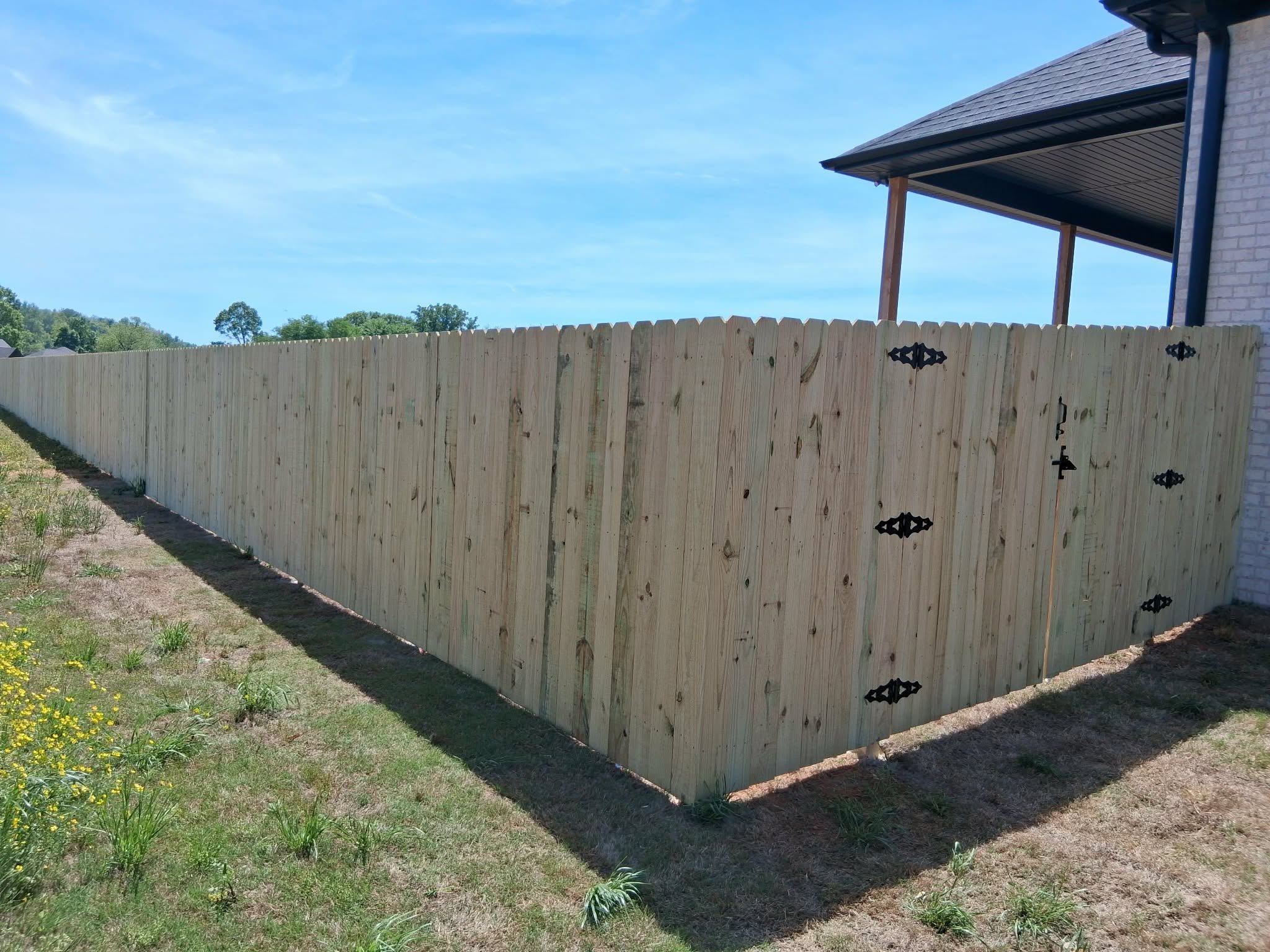 Dog-ear wood privacy fence with black gate hardware in Muscle Shoals, AL Dog-ear wood privacy fence with black gate hardware in Muscle Shoals, AL