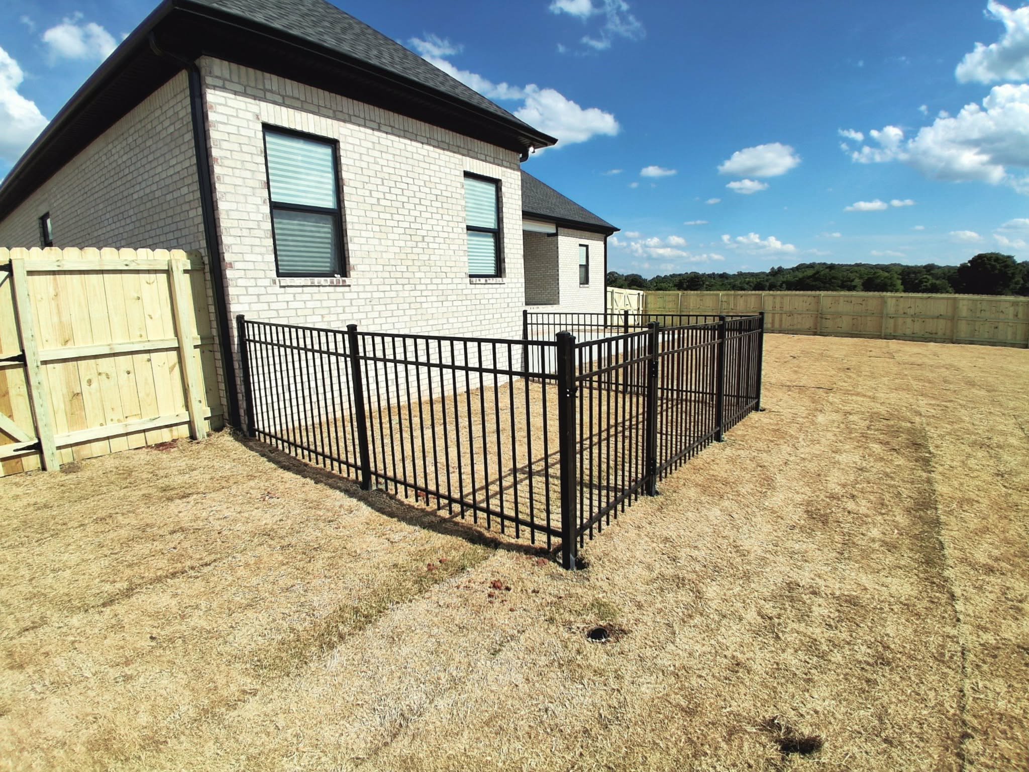 Black ornamental metal patio enclosure beside a brick home in Muscle Shoals, AL Black ornamental metal patio enclosure beside a brick home in Muscle Shoals, AL
