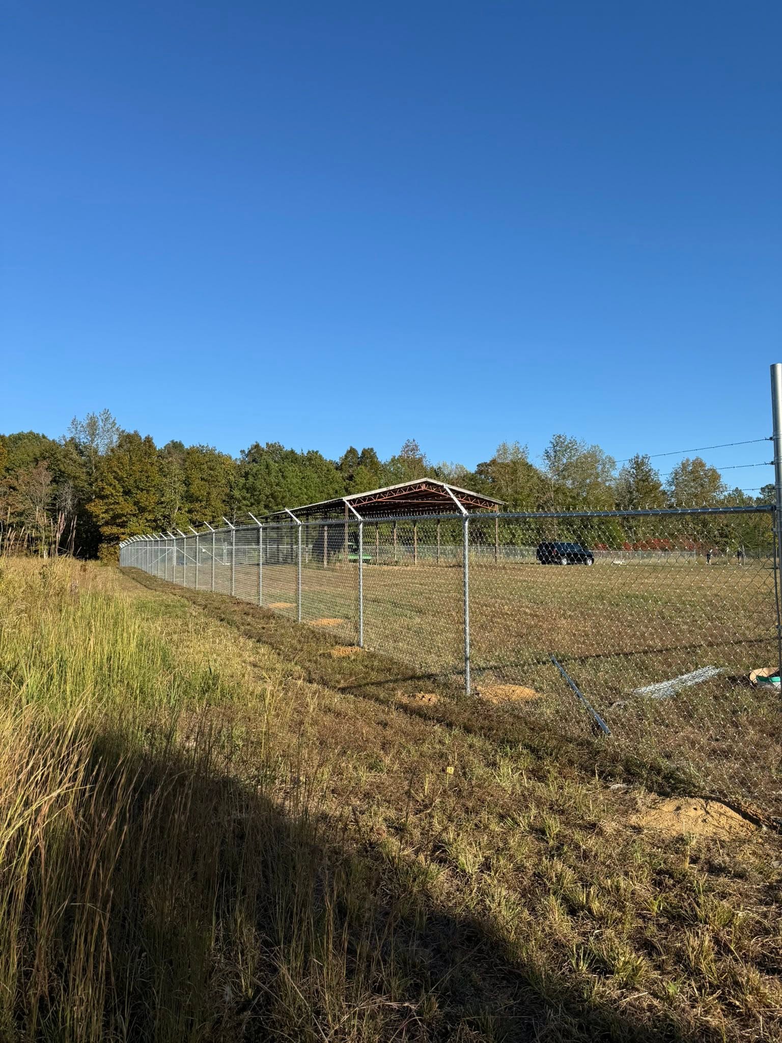 Chain-link perimeter fence with barbed wire for a commercial site near Muscle Shoals, AL Chain-link perimeter fence with barbed wire for a commercial site near Muscle Shoals, AL