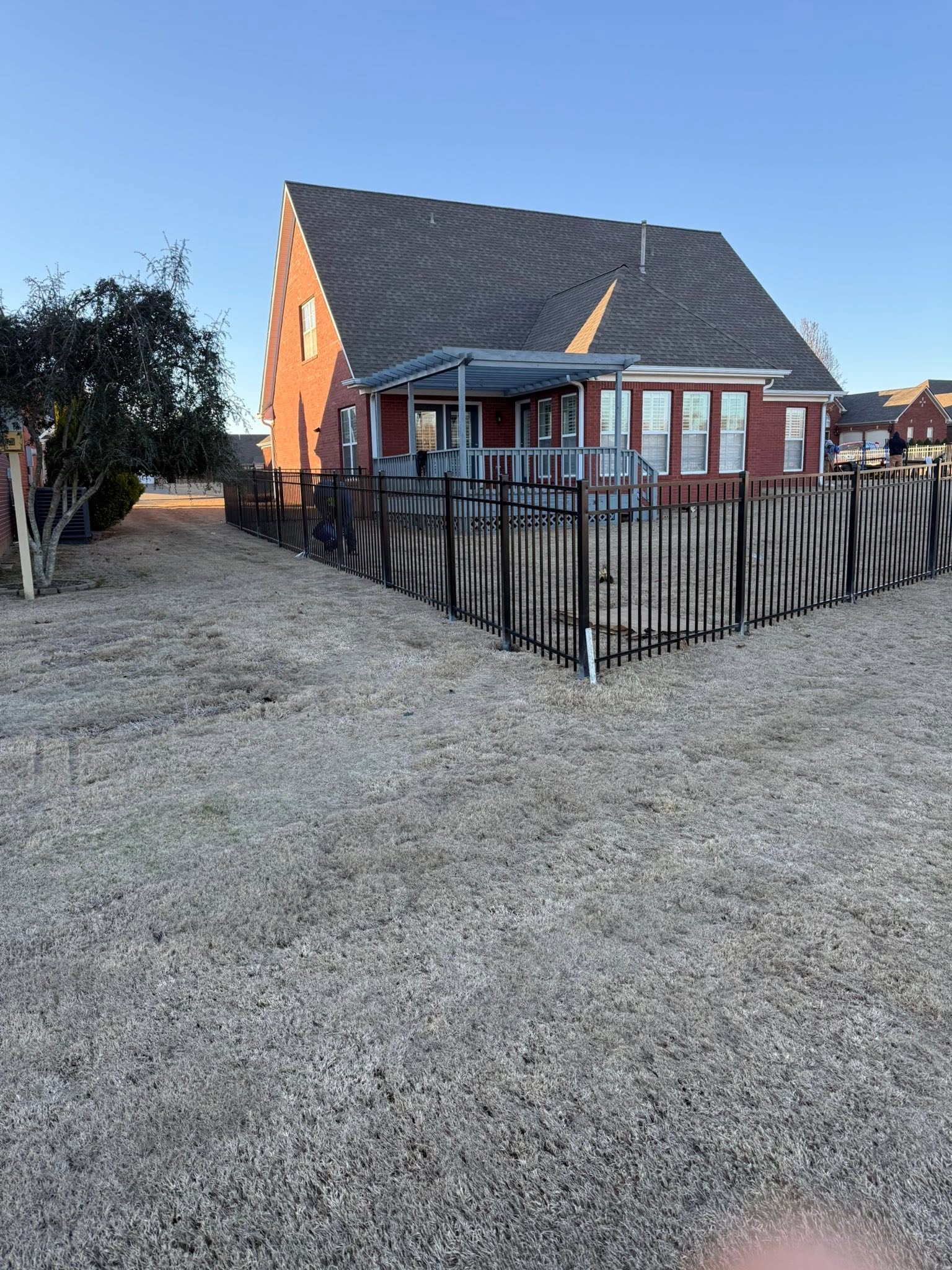 Black ornamental metal backyard fence around a brick home in Muscle Shoals, AL Black ornamental metal backyard fence around a brick home in Muscle Shoals, AL