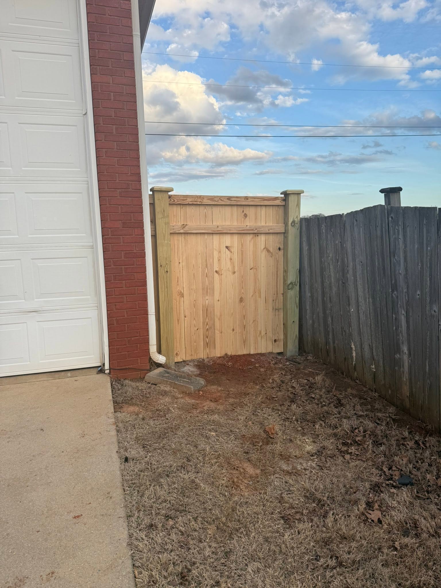 Side-yard wood fence gate connecting brick garage and existing fence in Colbert County, AL Side-yard wood fence gate connecting brick garage and existing fence in Colbert County, AL