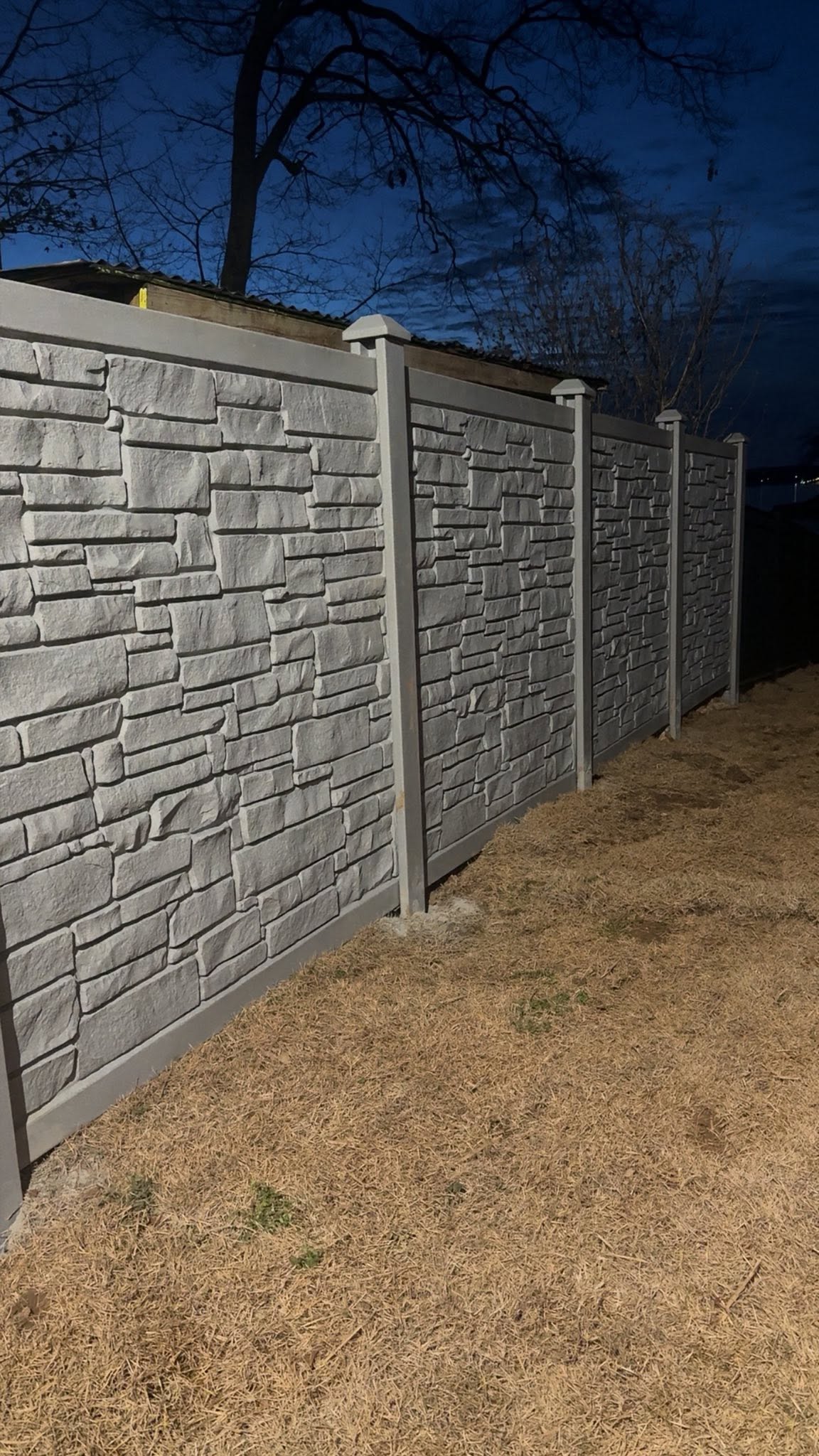 Stacked-stone textured privacy fence panels at dusk in Muscle Shoals, AL Stacked-stone textured privacy fence panels at dusk in Muscle Shoals, AL