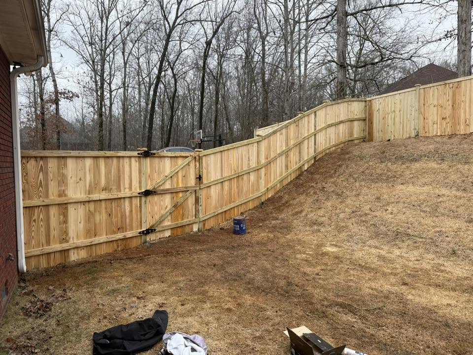 Wood privacy fence and double gate following a sloped yard in Northern Alabama Wood privacy fence and double gate following a sloped yard in Northern Alabama